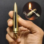 Hand holding bullet shape permanent match lighter producing yellow open flame