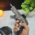 Hand holding 9mm pistol gun lighter producing blue torch flame