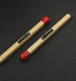 Matchstick style lighter lying on black textured surface