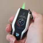 Hand holding Car Key Shape Lighter with green jet flame lit