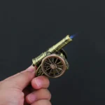 Hand holding Antique Artillery Cannon Lighter with blue jet flame lit
